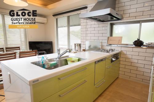 uma cozinha com um lavatório e um fogão em GLOCE 葉山 サーファーズログハウス l HAYAMA Surfers Log house em Hayama
