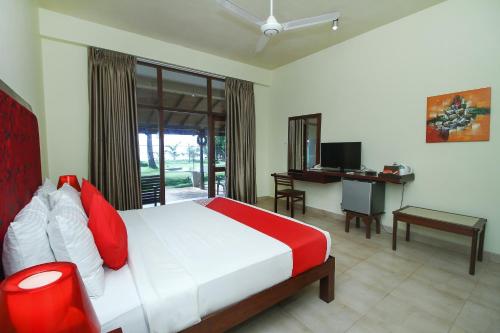 Un dormitorio con una cama y un escritorio con una computadora. en Maresia Beach Villa, en Wadduwa