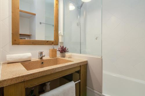 La salle de bains est pourvue d'un lavabo, d'un miroir et d'une baignoire. dans l'établissement Rivière 407 - Happy Rentals, à Chamonix-Mont-Blanc