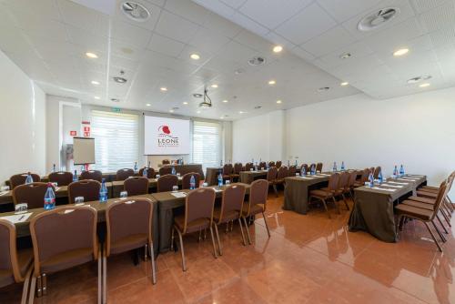 a conference room with tables and chairs and a screen at Best Western Plus Leone di Messapia Hotel & Conference in Lecce