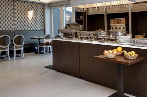 a kitchen with a counter with bowls of fruit on a table at Best Western Chiswick Palace & Suites London in London