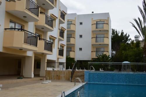 a building with a swimming pool in front of a building at Mariela Hotel Apartments in Polis Chrysochous