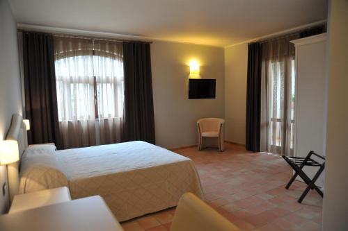 バロニッシにあるIl Casale Della Stellaのベッド、テーブル、椅子が備わるホテルルームです。