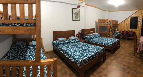 a room with three bunk beds and a staircase at Goodie's Place in Baguio