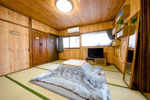 Un dormitorio con una cama en una habitación con paredes de madera. en Asahi, en Fujiyoshida