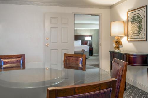 a room with a glass table and chairs and a bed at Crowne Plaza New Orleans French Qtr - Astor by IHG in New Orleans