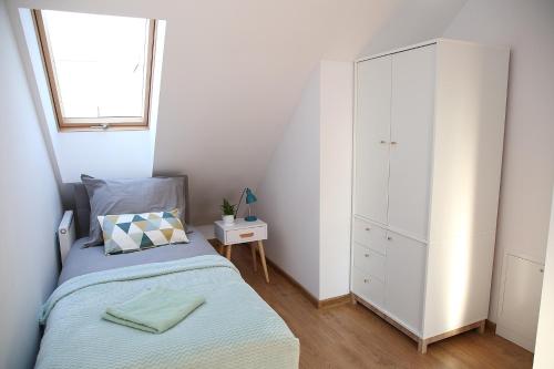 um pequeno quarto com uma cama e uma cómoda em Apartament Miętowy z 2 sypialniami i miejscem parkingowym em Kielce