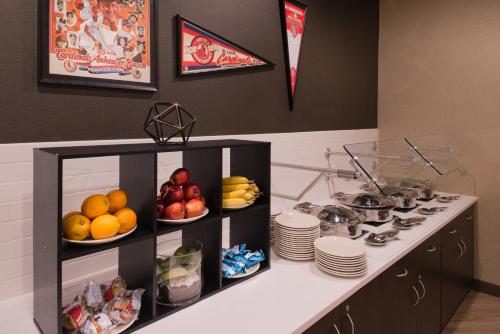 a kitchen with fruits and plates on a counter at The Arch Convention Hotel in Saint Louis
