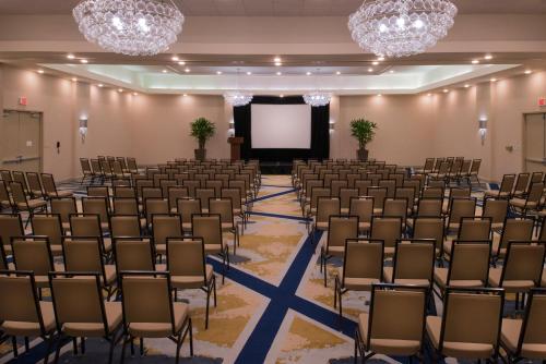 an empty room with chairs and a projection screen at The Arch Convention Hotel in Saint Louis