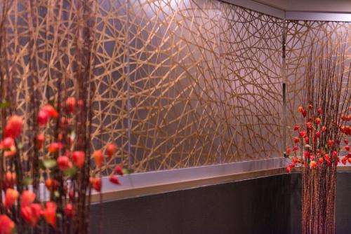 a room with red flowers on a wall with a mirror at The Arch Convention Hotel in Saint Louis