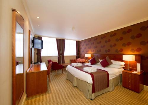 a hotel room with a bed and a desk at Crown & Mitre Hotel in Carlisle