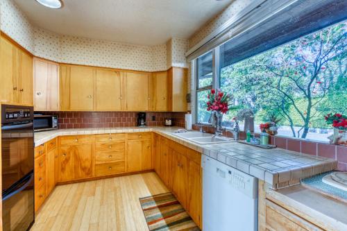 a kitchen with wooden cabinets and a large window at The Bridge and Balcony in North Bend