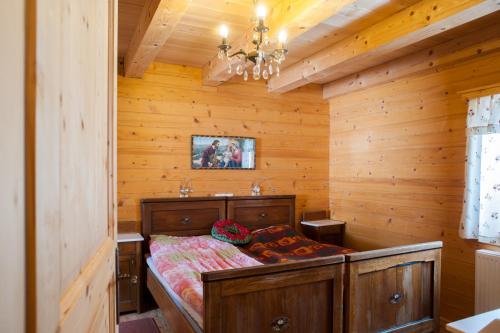 um quarto com uma cama num quarto de madeira em Podjelje em Podjelje