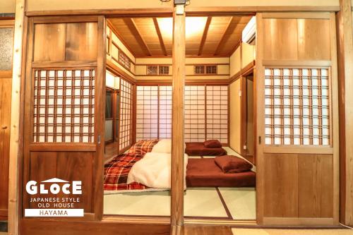 een kamer met 2 bedden in een Japans bedhuis bij GLOCE 葉山 囲炉裏付古民家ゲストハウス l HAYAMA Old Folk House with Sunken Hearth in Hayama