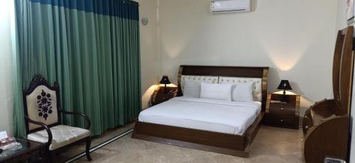 a bedroom with a bed and a green curtain at Executive Galaxy Guest House in Islamabad