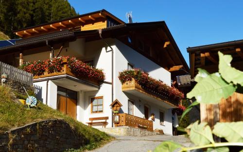 une maison blanche avec des boîtes de fleurs sur son côté dans l'établissement Steinhof, à Val di Mezzo