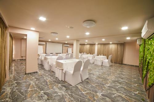 a banquet hall with white tables and white chairs at Aureole Mrida - A Boutique Hotel in Lonavala