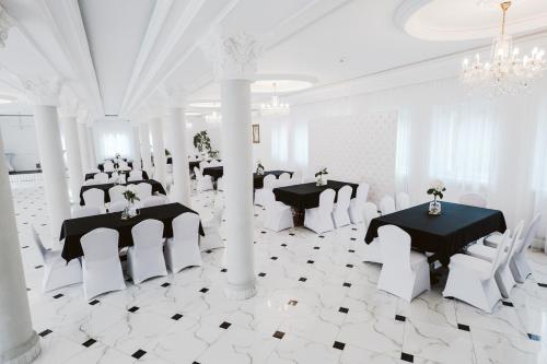 a white room with two tables and white chairs at Hotel Groman in Sękocin