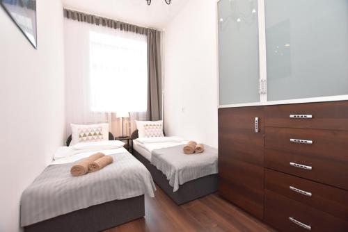 a bedroom with two beds and a large window at City Central Apartments Wrocław in Wrocław