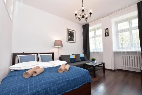 a bedroom with a blue bed and a couch at City Central Apartments Wrocław in Wrocław