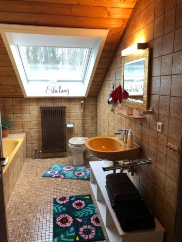La salle de bains est pourvue d'un lavabo, de toilettes et d'une fenêtre. dans l'établissement Gemütlich wohnen in Messenähe, Feenzian, à Friedrichshafen