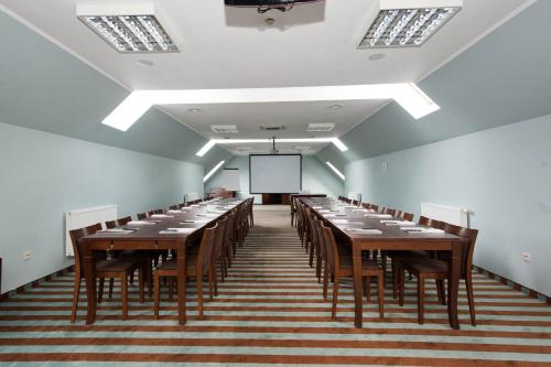 a large room with tables and chairs and a screen at Sandra Spa Karpacz & Aquapark in Karpacz