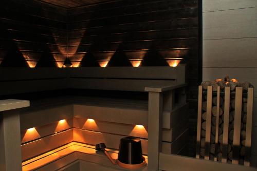 uma lareira numa cozinha com luzes acesas em Hotelli Salpa em Luumäki