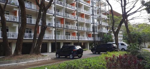 two cars parked in front of a large building at Pico de Loro Jacana B in Nasugbu