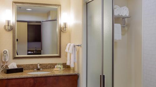 a bathroom with a sink and a mirror at Holiday Inn Oklahoma City Airport, an IHG Hotel in Oklahoma City