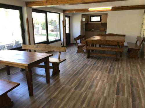 Neda's House في Cherven: غرفة مليئة بالطاولات الخشبية والمقاعد