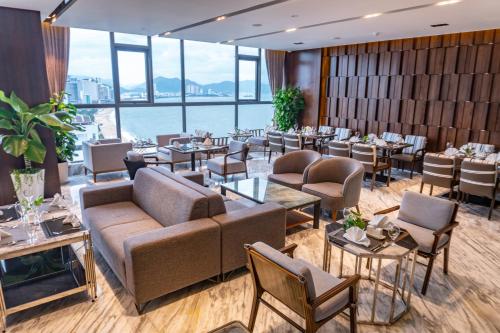 a restaurant with tables and chairs and a large window at Queen Ann Nha Trang Hotel in Nha Trang