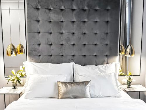 a bedroom with a black padded headboard and a bed with white pillows at MINT Boutique Studio Apartments in Zagreb