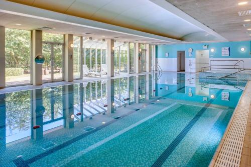 uma piscina interior com uma grande piscina em Holiday Inn Colchester, an IHG Hotel em Colchester