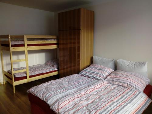 a bedroom with a bed and two bunk beds at Apartmán Špičák in Jiřetín pod Bukovou