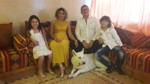 a family sitting on a couch with a dog at Dar Rio Oro in Dakhla
