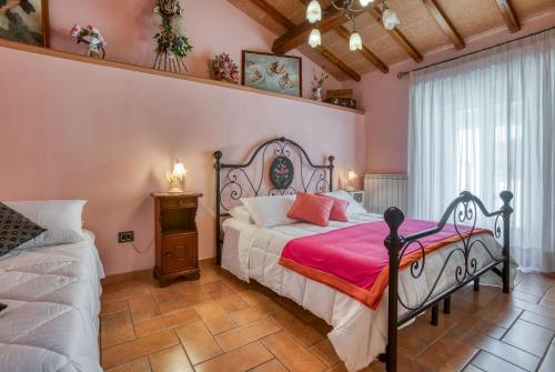 una camera da letto con un grande letto e pareti rosa di Palazzetto San Lorenzo a Viterbo