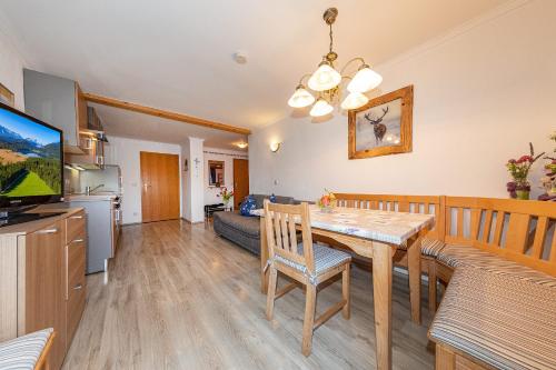 a kitchen and living room with a dining room table at Gästehaus Simon in Krün