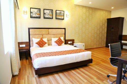 a bedroom with a bed and a desk and a chair at The Continentti Whitefield in Bangalore