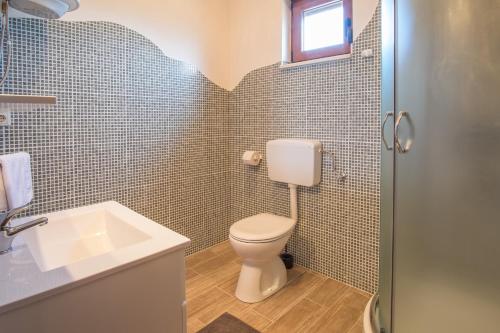 łazienka z toaletą i umywalką w obiekcie Villa Dijana East w mieście Hrahorić
