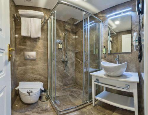 a bathroom with a tub, toilet, sink and shower stall at Ada Karakoy Hotel - Special Category in Istanbul