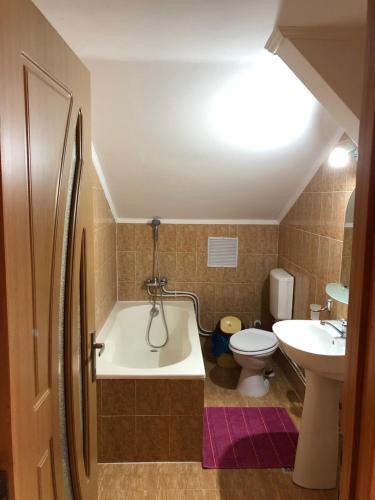 een badkamer met een bad, een toilet en een wastafel bij Casa Maria in Gura Humorului