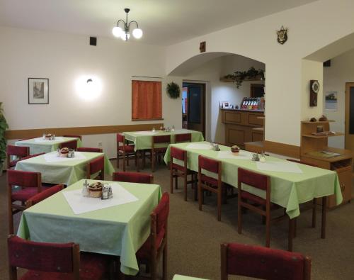restauracja ze stołami i krzesłami z zieloną tkaniną w obiekcie Pension Skály w mieście Teplice nad Metují