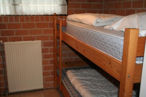 Ce lit se trouve dans un dortoir doté de 2 lits superposés et d'un mur en briques. dans l'établissement Rekerlanden 187, à Schoorldam