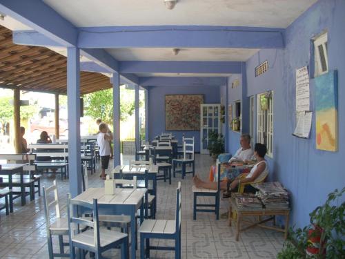 um restaurante com paredes azuis, mesas e cadeiras em Itaoca Pousada Camping em Itaipava