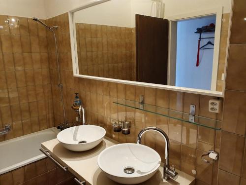 a bathroom with two sinks and a mirror and a tub at Apartment in Lenzerheide in Lenzerheide