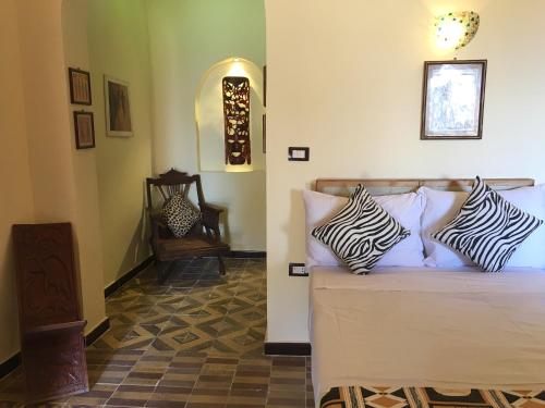 a bedroom with a bed with zebra pillows on it at Djorff Palace in Luxor