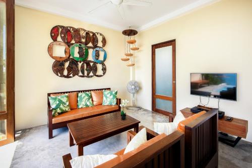 a living room with a couch and a tv at Philip's Villa in Koh Tao