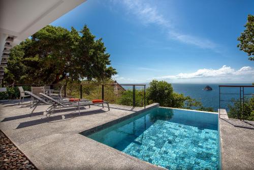 a swimming pool with a view of the ocean at Philip's Villa in Koh Tao
