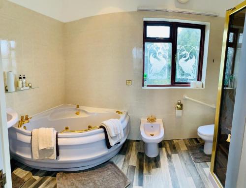 uma casa de banho branca com uma banheira e um WC em White Wings em Nuneaton