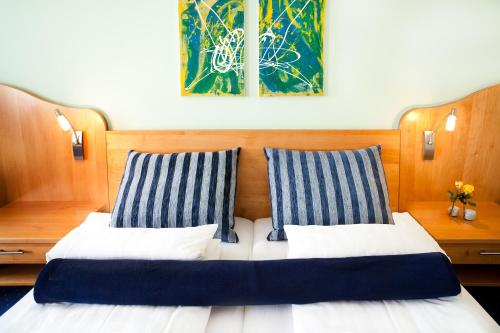 una camera con 2 letti con cuscini a righe blu e bianche di Gasthof Hotel Lang a Rauchwart im Burgenland